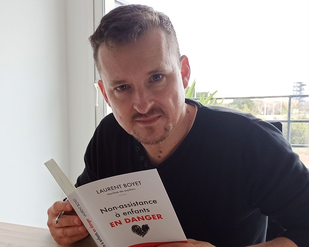 Portraifoto von Laurent Boyet mit seinem Buch "Non-assistance à enfants EN DANGER"